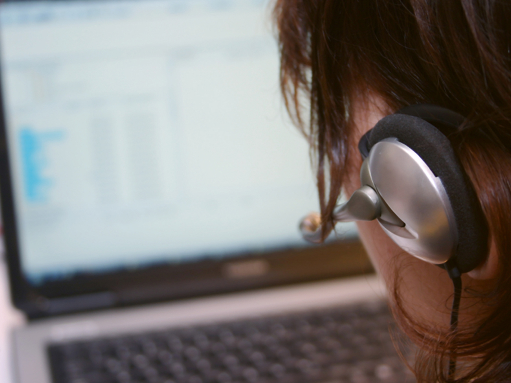 Person looking at computer screen wearing headphones